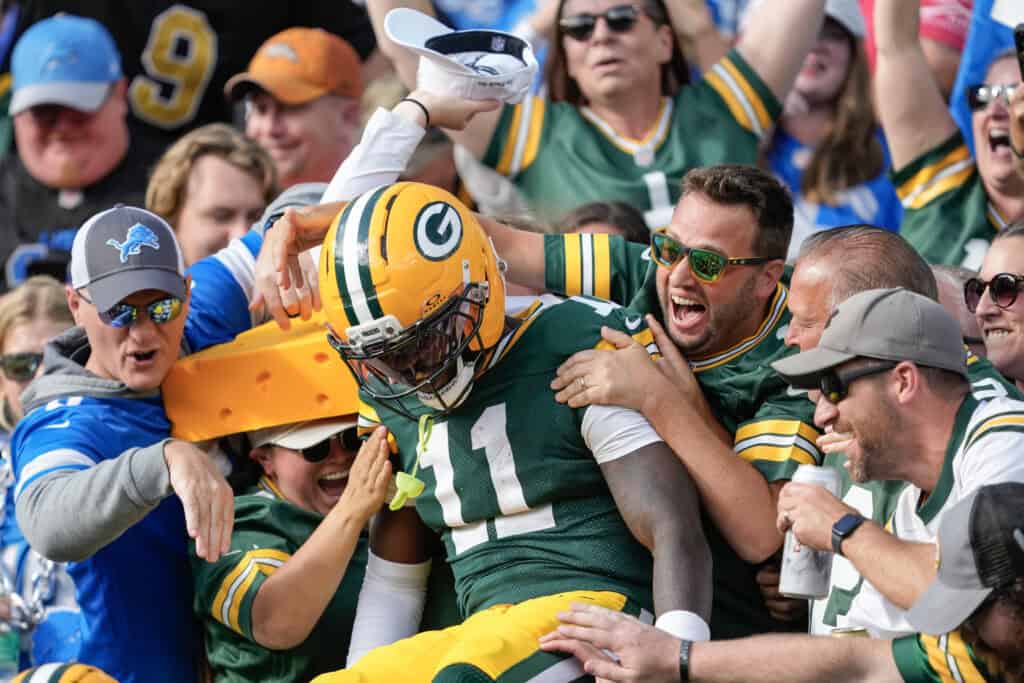 GREEN BAY, WISCONSIN - SEPTEMBER 07: Jayden Reed #11 of the Green Bay Packers jumps into the stands after scoring during the second quarter against the Detroit Lions at Lambeau Field on September 07, 2025 in Green Bay, Wisconsin.